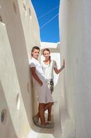 joven pareja enamorada caminando por las estrechas calles del pueblo emporio, santorini, grecia foto