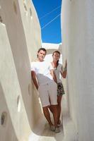 pareja joven caminando en el antiguo pueblo griego en la isla de santorini, grecia foto