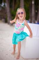 retrato niña adorable en una playa blanca tropical foto