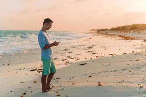 joven tomando selfie en el fondo de la playa el mar foto