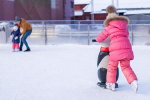 adorable niña patinando en la pista de hielo foto