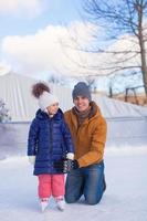 felices vacaciones familiares en pista de patinaje foto