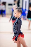 hermosa niña gimnasta activa con su actuación en la alfombra foto