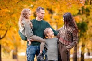 retrato de familia feliz de cuatro en día de otoño foto