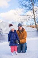 felices vacaciones familiares en pista de patinaje foto