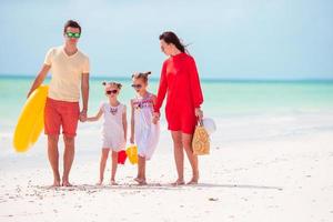 Family of four on beach vacation with inflatable ring and toy buckets photo