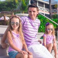 Family of three sitting on beach enjoying ocean view photo