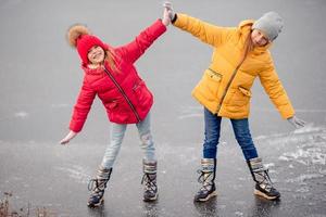 Adorable little girls skating on the ice-rink photo