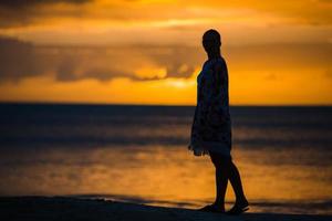 mujer de moda joven en vestido verde en la playa foto