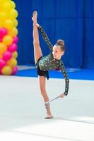 Beautiful little gymnast girl on the carpet on the competition photo