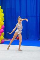 hermosa niña gimnasta en la alfombra de la competencia foto