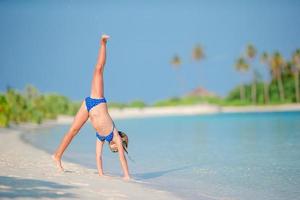 Adorable little girl at beach during summer vacation photo