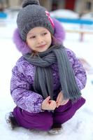 primer plano de una linda niña feliz divirtiéndose en la nieve en un soleado día de invierno foto