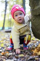 Portrait of Little adorable girl walking alone in autumn park photo