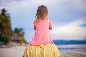 Little girl have fun with her dad at tropical beach photo