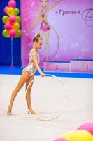 Beautiful little gymnast girl on the carpet on the competition photo