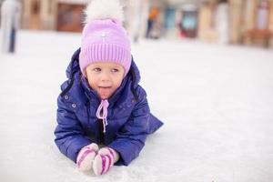 Adorable little girl laying on skating rink after the fall photo