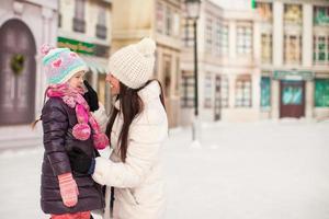 Adorable little girl and her young mother on a skating rink photo