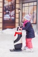 Adorable little happy girl skating on the ice-rink photo