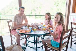 Family having breakfast at outdoor cafe on terrace. photo