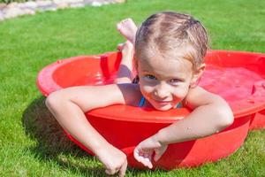 retrato de una niña encantadora y relajante disfrutando de sus vacaciones en una piscina pequeña foto