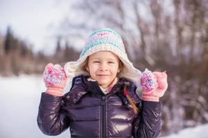 Portrait of little adorable happy girl in the snow sunny winter day photo