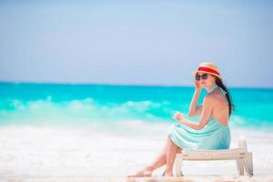 Young woman on a tropical beach with hat photo