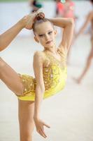 pequeña gimnasta entrenando en la alfombra y lista para las competencias foto