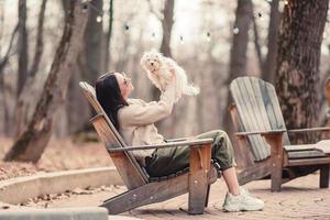 Woman with a white puppy. A puppy in the hands of a beautiful girl photo