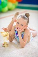 hermosa pequeña gimnasta entrenando en la alfombra y lista para las competiciones
