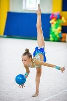 hermosa niña gimnasta activa con su actuación en la alfombra foto