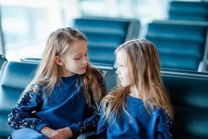 niñas adorables en el aeropuerto cerca de una gran ventana foto