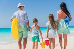 Happy beautiful family on white beach having fun photo