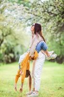 Family of mother and daughter in blooming cherry garden photo