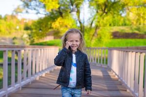 Adorable little girl at warm autumn day outdoors photo