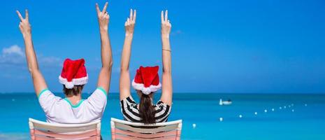 Young romantic couple in Santa hats during beach vacation photo