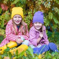 Two adorable girls in forest at warm sunny autumn day photo