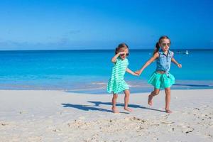 Little girls having fun during tropical beach vacation photo