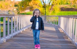 Happy little girl at warm autumn day outdoors photo