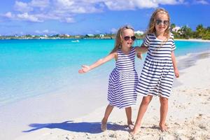 Adorable little girls enjoying summer beach vacation photo