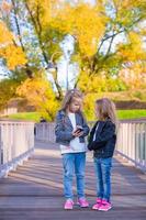 Adorable little girls at warm autumn day outdoors photo