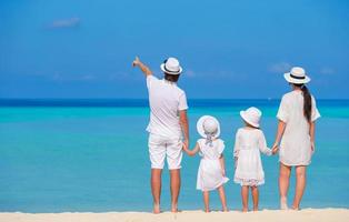 hermoso paisaje de playa tropical con familia en blanco disfrutando de las vacaciones de verano foto
