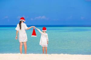 Young mother and little girl in Santa hat photo