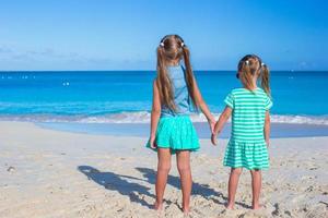 Little girls having fun during tropical beach vacation photo