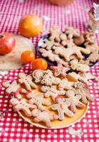 Raw gingerbread men with glaze on a baking sheet photo