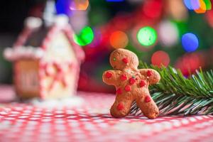 Close-up of gingerbread man background candy ginger house and Christmas tree lights photo