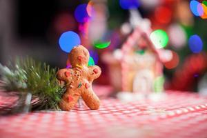 Close-up of gingerbread man background candy ginger house and Christmas tree lights photo