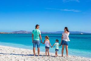 Happy family of four during summer beach vacation photo