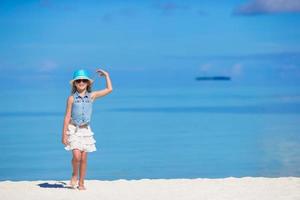 Adorable little girl at beach during summer vacation photo