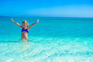 Little happy girl enjoying beach vacation photo